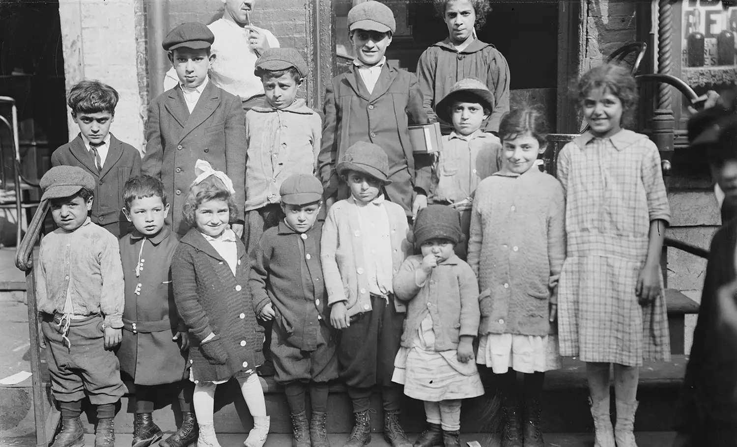 Fourteen boys and girls of various ages are arranged in a candid group photo. 