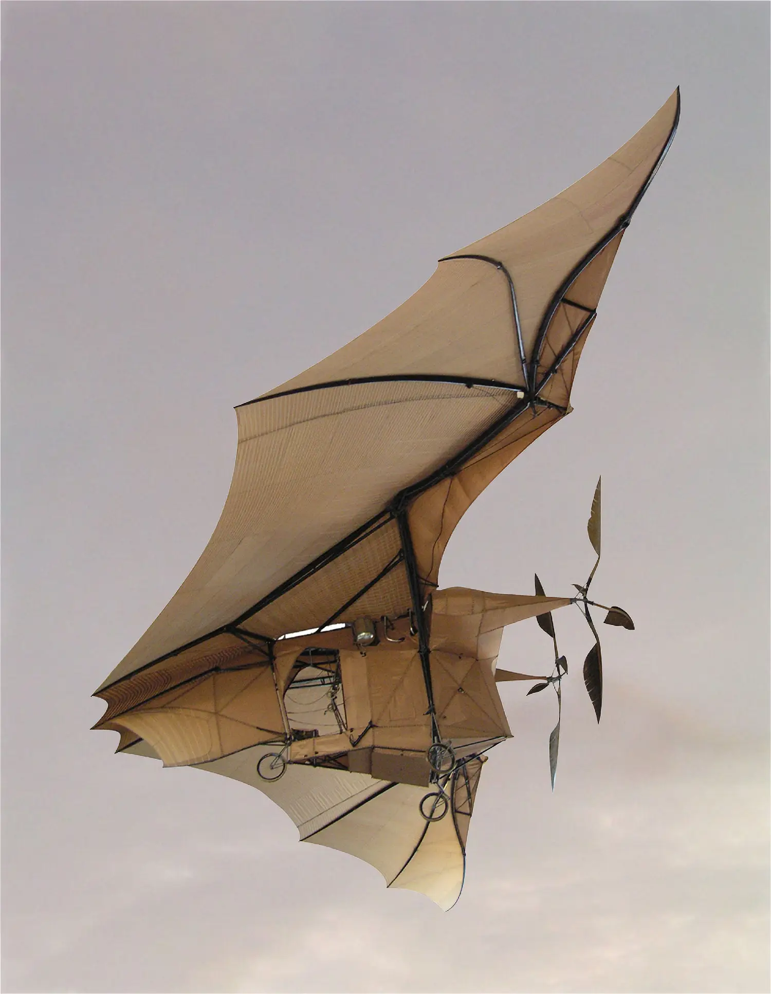 An old, experimental aircraft that appears to be made of canvas and metal tubing.