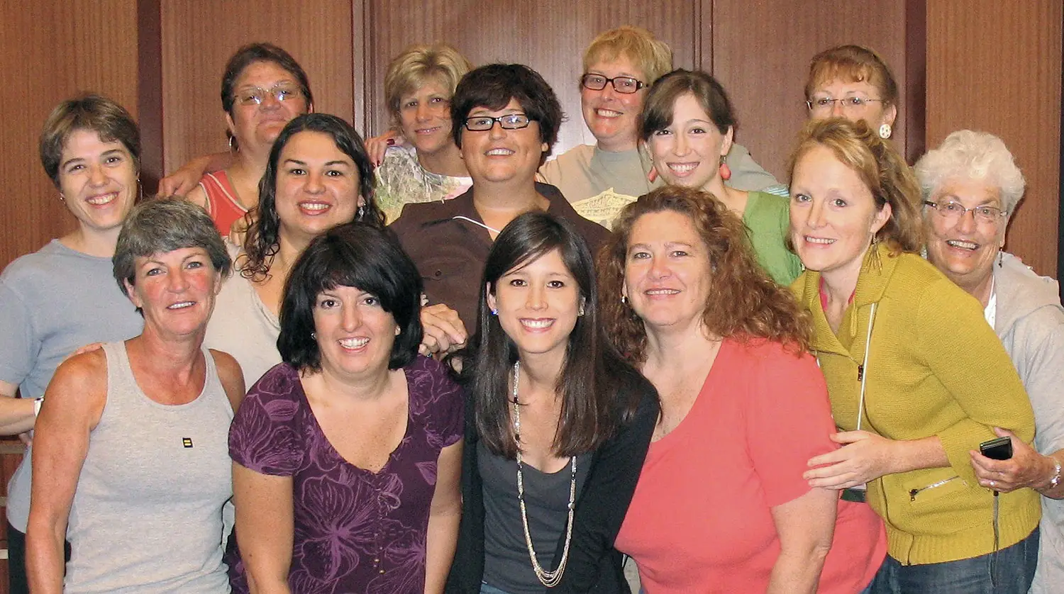 A group photo of feminine presenting people across many ages.