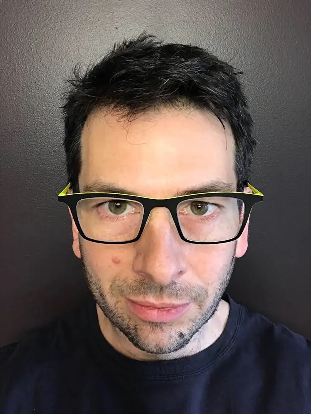 Two photos of a masculine face. The first shows him without glasses and a beard, with the photo taken from below, emphasizing his jaw size. In the second, he is wearing glasses, sporting short stubble, and the photo is taken from above, causing his jaw to appear smaller.