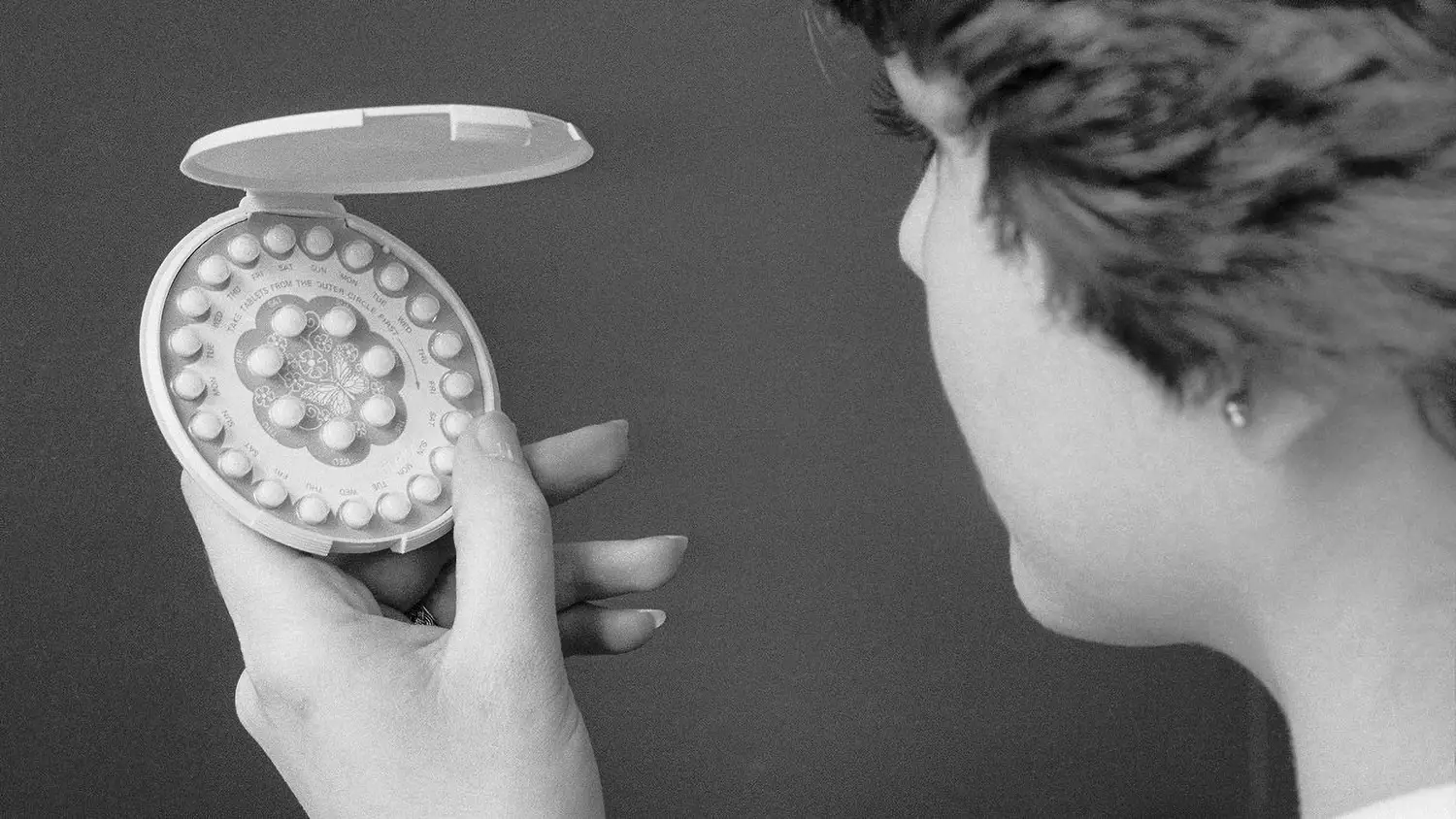 A package of birth control pills, embellished with a butterfly illustration, in a clamshell container.