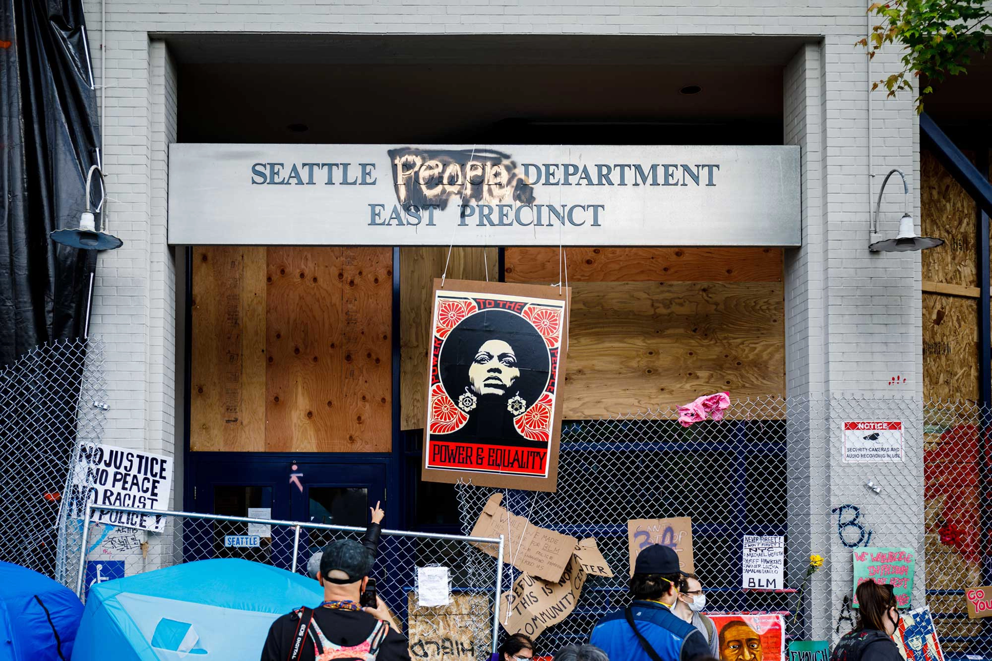 A portrait of Angela Davis hangs in front of an abandoned Seattle Police precinct within the CHAZ.