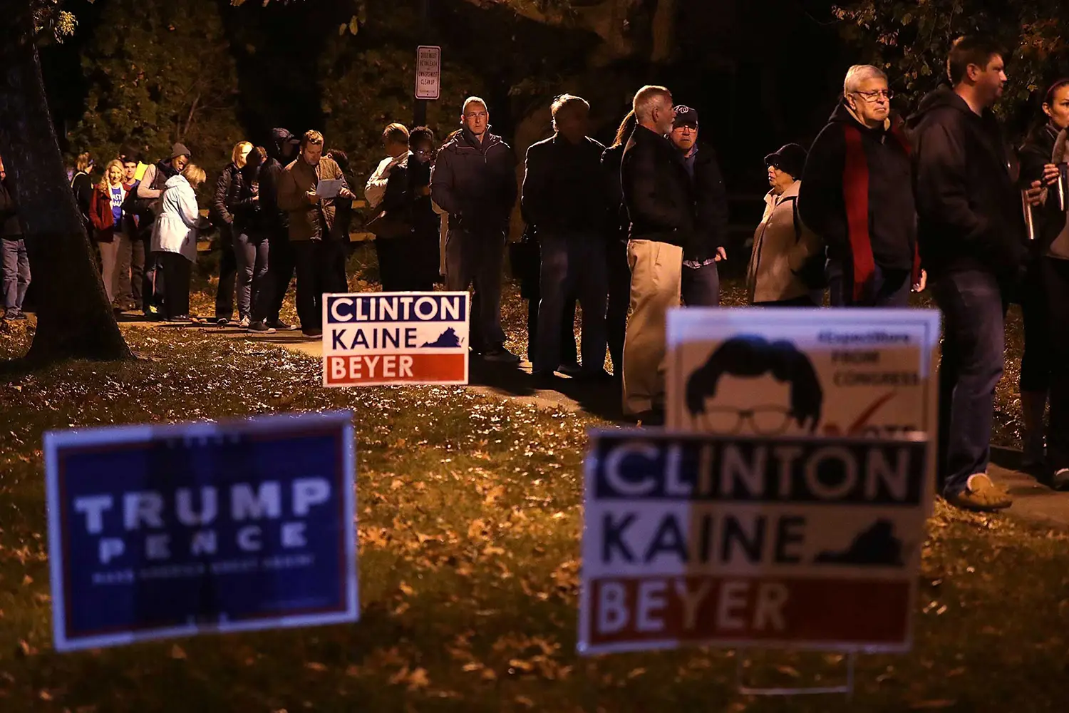 A line of voters standing behind Hilary Clinton and Donald Trump placards.